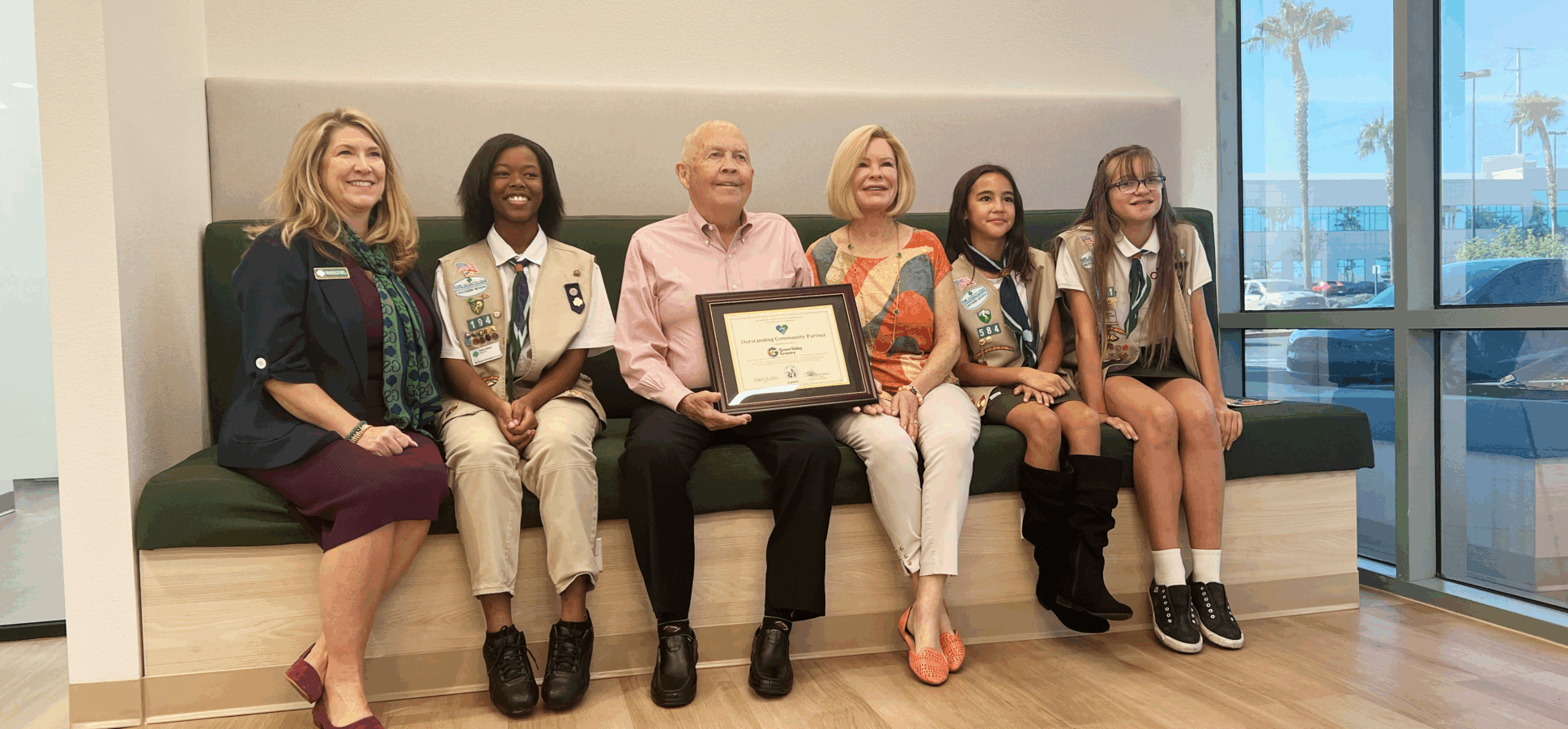 Rick and Jeri Crawford receive an appreciation certificate from the Girl Scouts, joined by troop members and representatives.